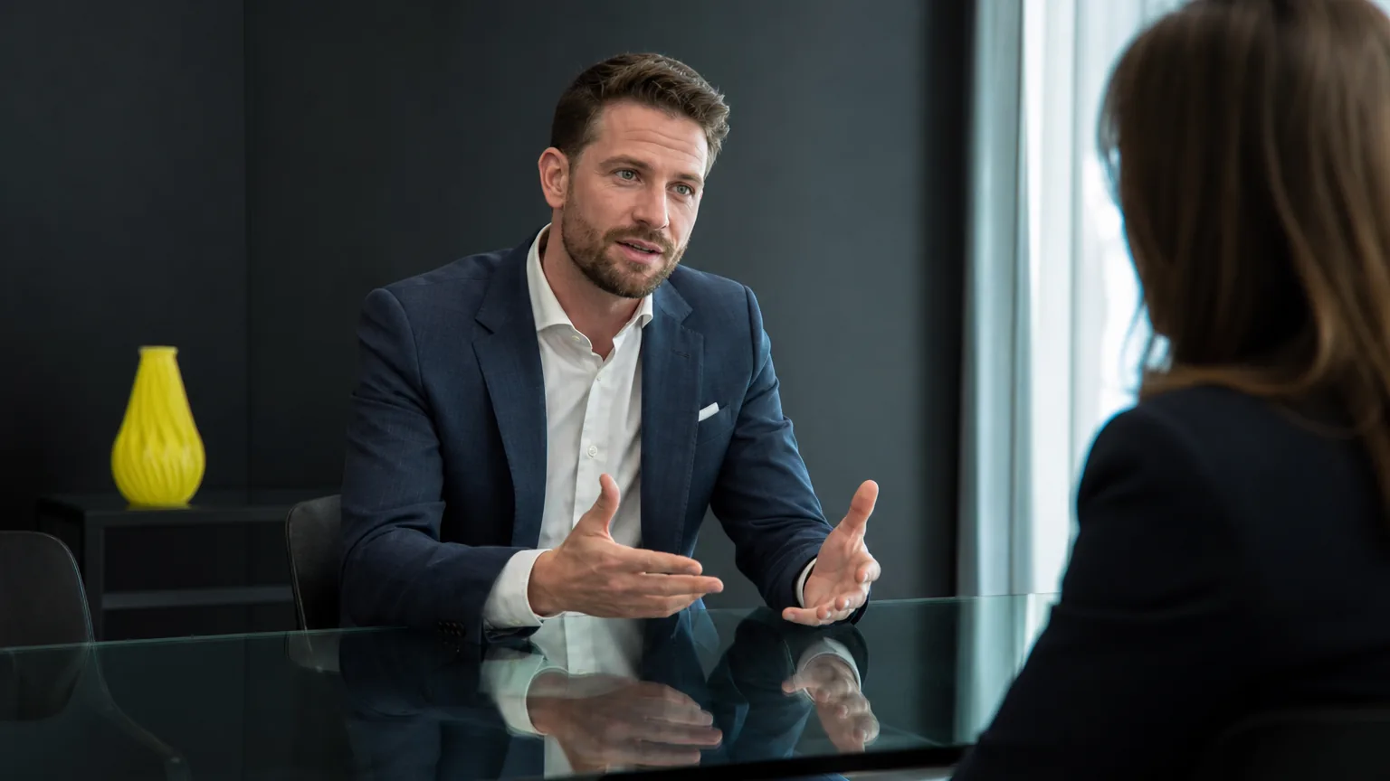 Verkaufsfachperson im Kundengespraech am Glaskonferenztisch